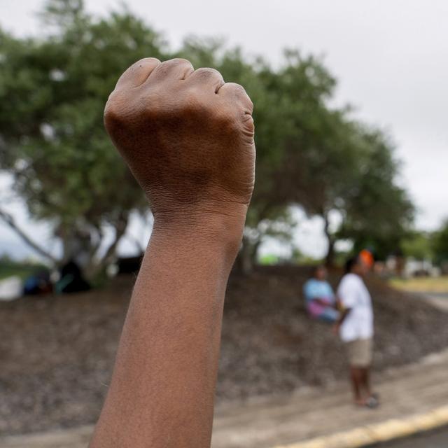 Une femme noire au poing levé en Nouvelle-Calédonie. [Keystone/AP Photo - Nicolas Job]