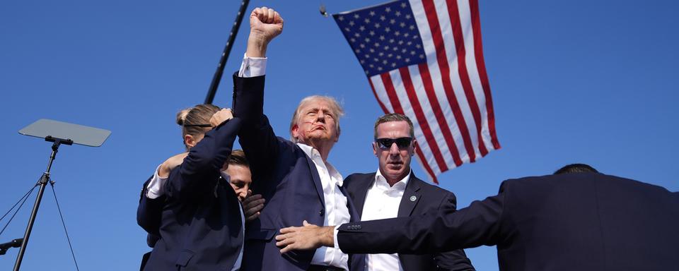 La photo devenue iconique de Donald Trump le visage ensanglanté. [Keystone - AP Photo/Evan Vucci]