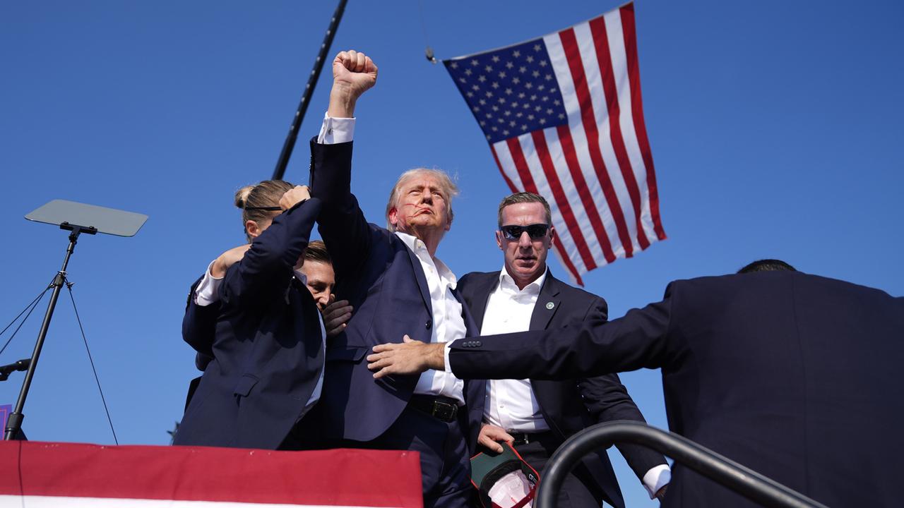 La photo devenue iconique de Donald Trump le visage ensanglanté. [Keystone - AP Photo/Evan Vucci]