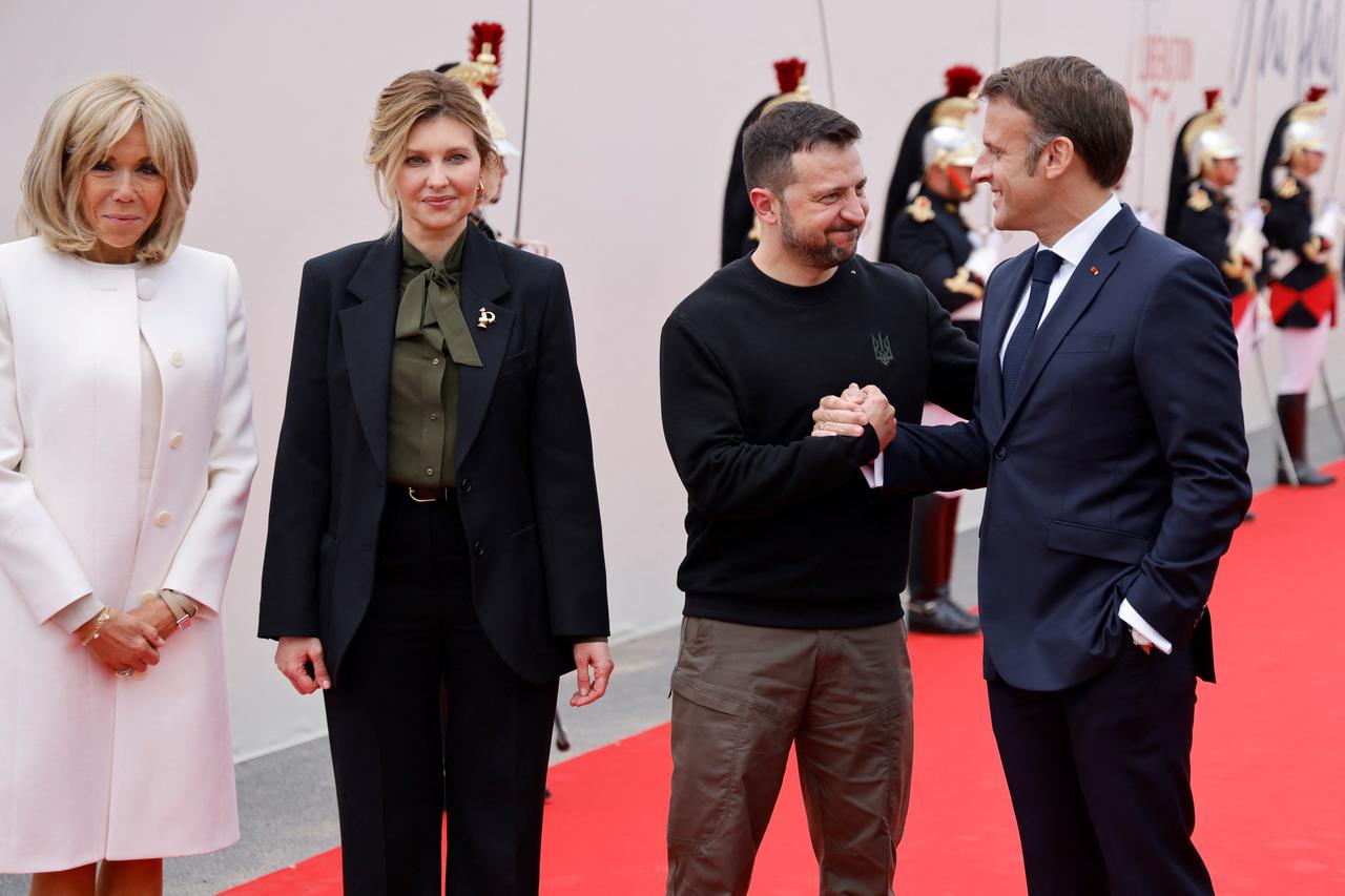 Brigitte Macron et le président français Emmanuel Macron saluent le président ukrainien Volodymyr Zelensky et son épouse Olena Zelenska à leur arrivée pour assister à la cérémonie commémorative internationale à Omaha Beach, à Saint-Laurent-sur-Mer, dans le nord-ouest de la France, le 6 juin 2024. [via REUTERS - LUDOVIC MARIN]