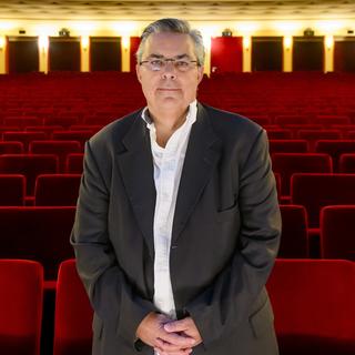 Frédéric Maire, directeur de la Cinémathèque suisse, pose dans la salle Freddy Buache du cinéma Capitole à Lausanne après sa rénovation le vendredi 9 février 2024. [Keystone - Jean-Christophe Bott]