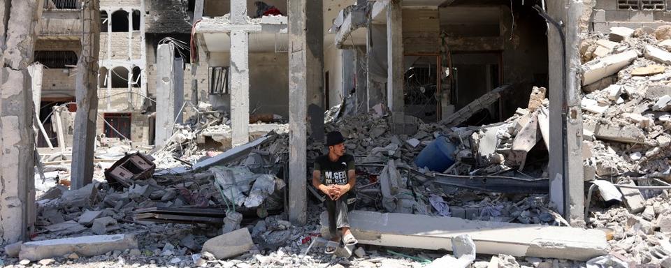 Un homme dans les débris d'un bâtiment dans le quartier de Choujaïya, dans la ville de Gaza. [afp - Omar al-Qattaa]