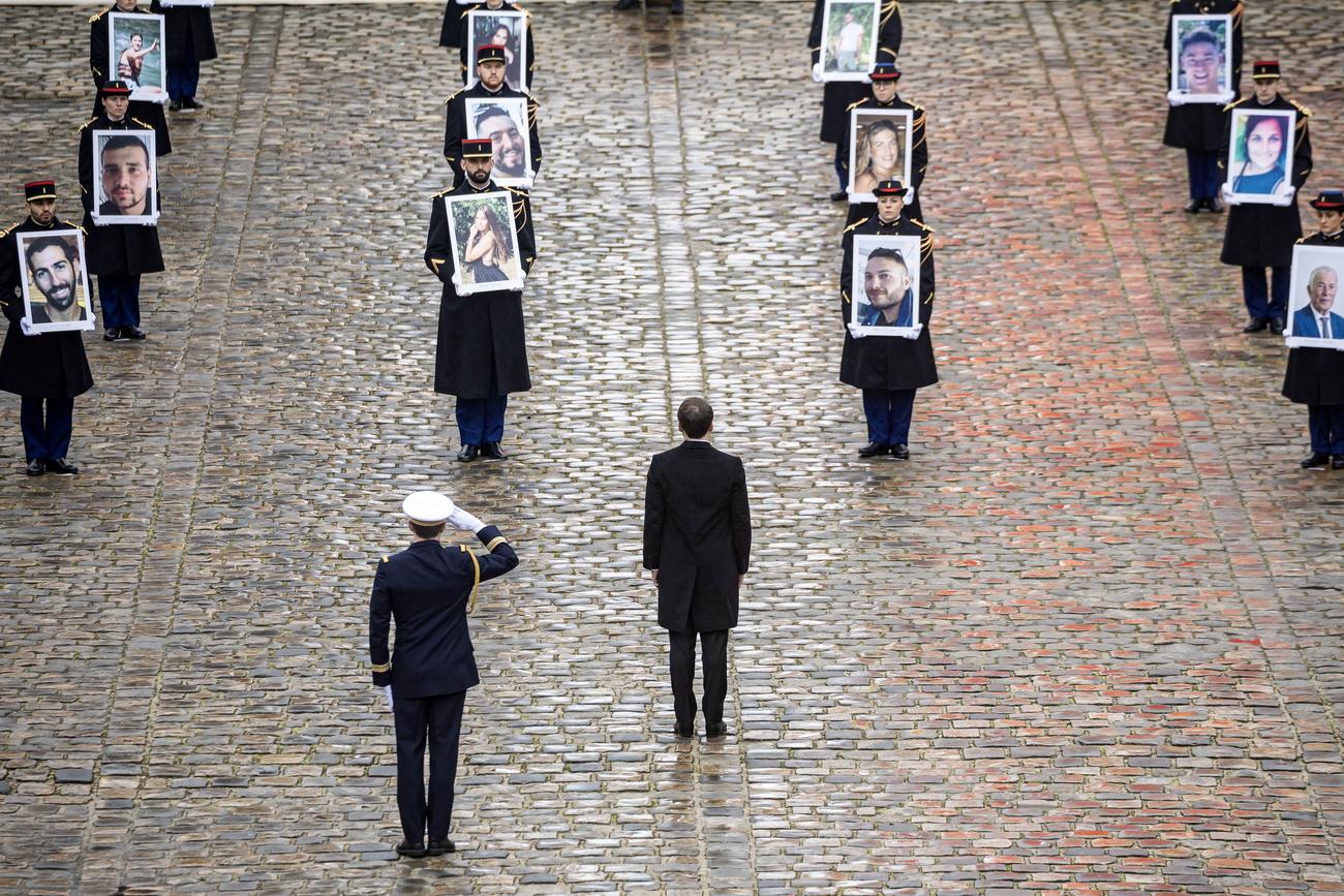 Le président Emmanuel Macron fait face aux portraits des Français tués lors de l'attaque du 7 octobre. [KEYSTONE - CHRISTOPHE PETIT TESSON]