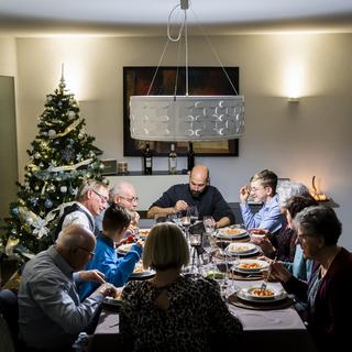 Un repas organisé pendant les fêtes de Noël (image d'illustration). [Keystone - Jean-Christophe Bott]