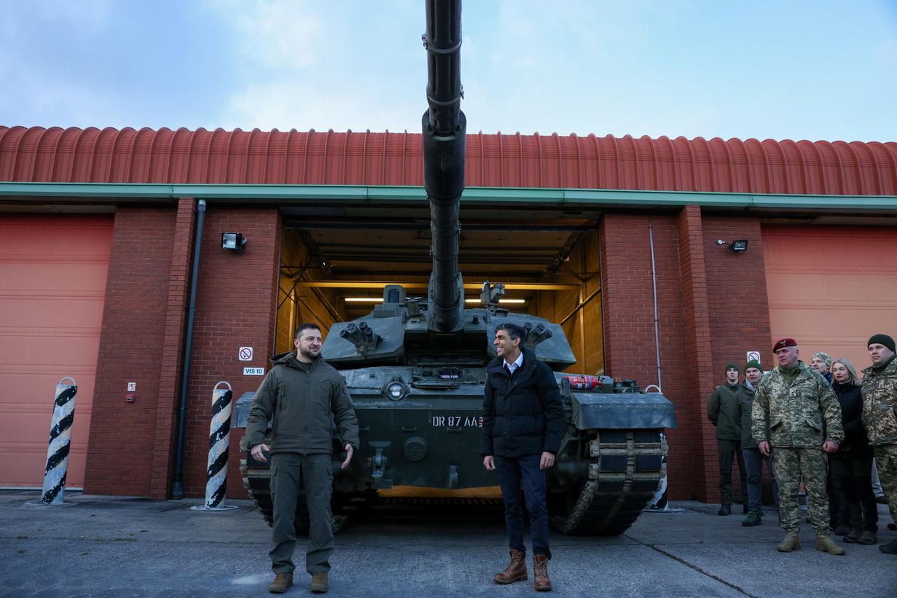 Le président ukrainien Volodymyr Zelensky en compagnie de l'ancien Premier ministre britannique Rishi Sunak en février 2023, devant un tank Challenger 2. [KEYSTONE - HOLLIE ADAMS / POOL]