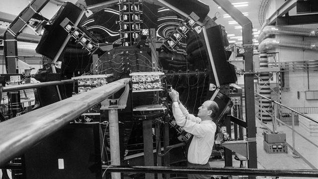 Des travaux de révision sont effectués sur un accélérateur de particules en novembre 1971 au CERN. [Keystone]