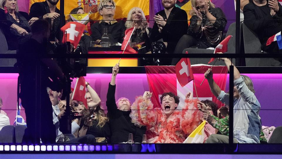 Nemo, qui a interprété la chanson "The Code", célèbre l'annonce des votes des juges lors de la grande finale du Concours Eurovision de la chanson à Malmö, en Suède, le 11 mai 2024. [KEYSTONE - MARTIN MEISSNER]
