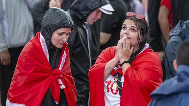 Des supporters suisses déçues à l'issue du match. [KEYSTONE - MARTIAL TREZZINI]