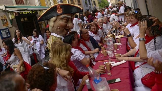 Un membre du "défilé des géants" pose avec des festivaliers lors des fêtes de San Fermín à Pampelune, en Espagne, le lundi 8 juillet 2024. [KEYSTONE - ALVARO BARRIENTOS]