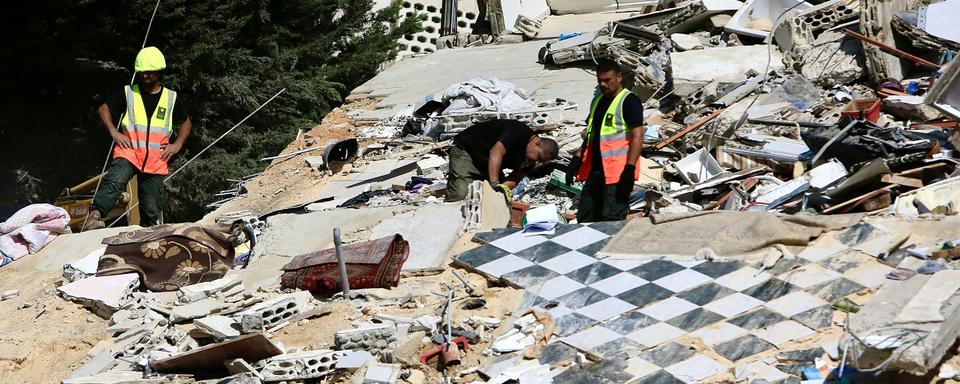 Search and rescue team members, together with locals, work to find bodies under the rubble of buildings destroyed in an Israeli airstrike the previous day in Ain el-Delb neighborhood, east of the port city of Sidon, southern Lebanon, 30 September 2024. According to the UN Humanitarian Coordinator in Lebanon, Imran Riza, the recent escalations in Lebanon have led to widespread destruction of homes and infrastructure across the country. At least 700 people have been killed, thousands have been injured, and nearly 120,000 people have been displaced in the past week. [Keystone]