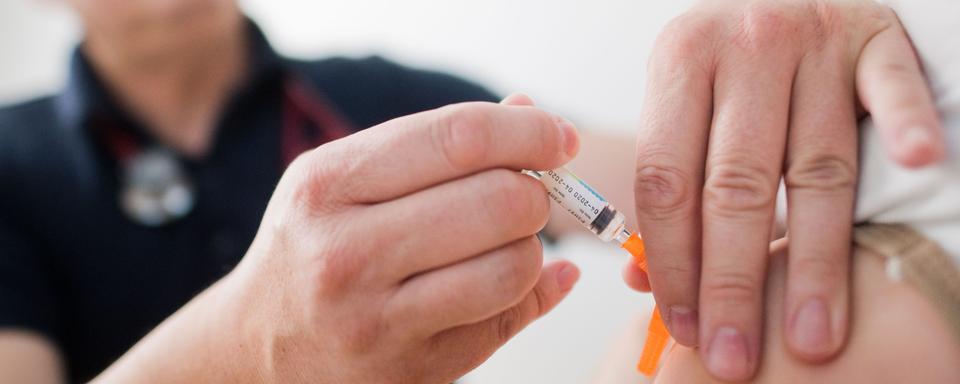 Un enfant qui reçoit un vaccin (image d'illustration). [DPA / KEYSTONE - Julian Stratenschulte]