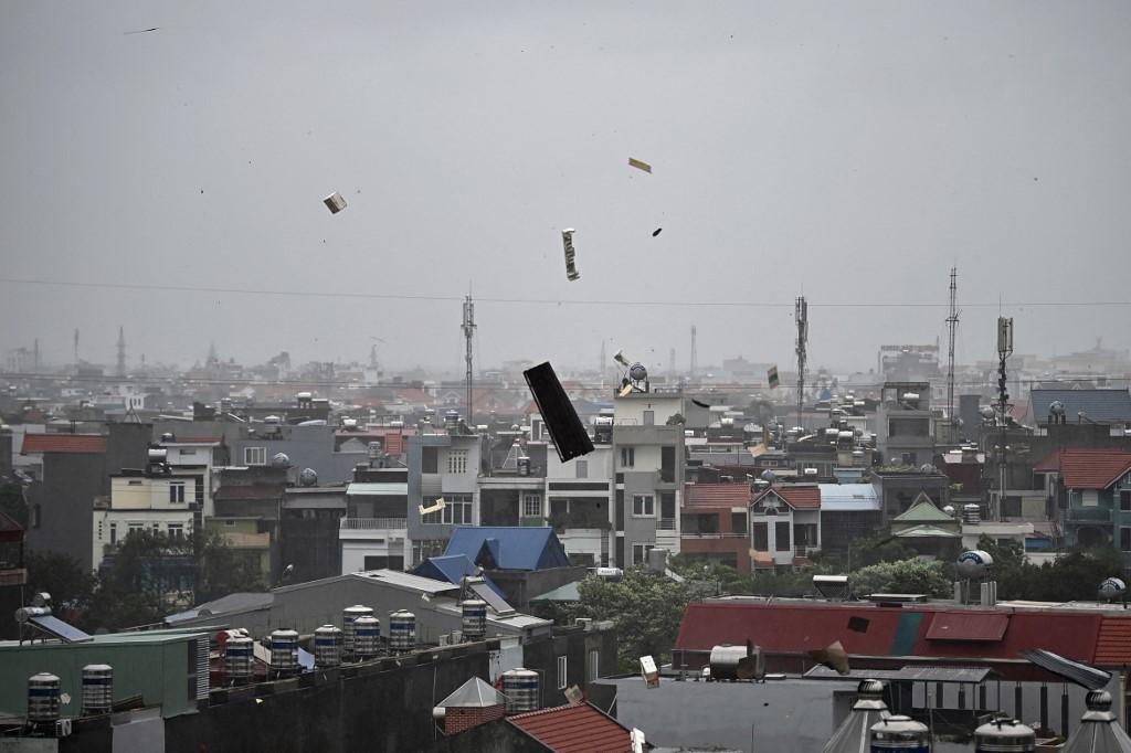 Des débris volent en l'air alors que les fortes pluies et les vents violents du super typhon Yagi touchent Hai Phong, le 7 septembre 2024. [AFP - NHAC NGUYEN]