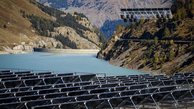 Des panneaux solaires flottants en train d'être installés dans un réservoir d'eau alpin de la commune de Bourg-Saint-Pierre (VS). [Keystone - Valentin Flauraud]
