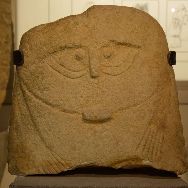 Une photographie de la stèle des Roumanis, découverte à Saint-Théodorit (Gard, France), avec ses tatouages/scarifications "en yeux de chouette" - datée entre 2800 et 2500 avant J.-C. [©Jules Masson Mourey]