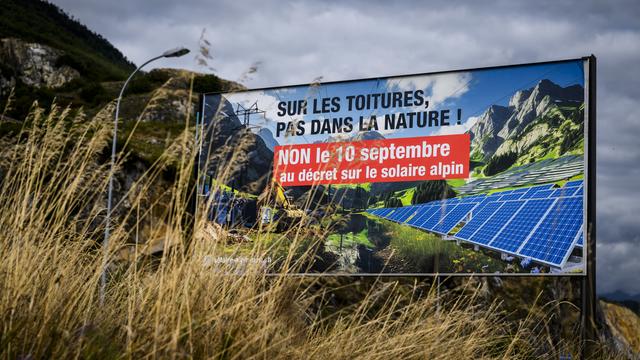 Une affiche des opposants au projet de grandes installations photovoltaïques dans les Alpes. [Keystone - Jean-Christophe Bott]
