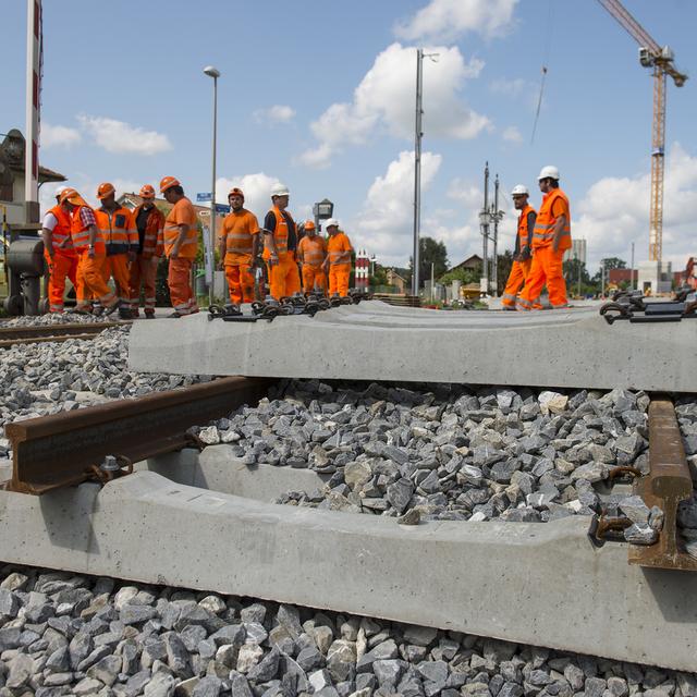 Des ouvriers sur un chantier de gare dans le canton de Fribourg (image d'illustration). [Keystone - Jean-Christophe Bott]