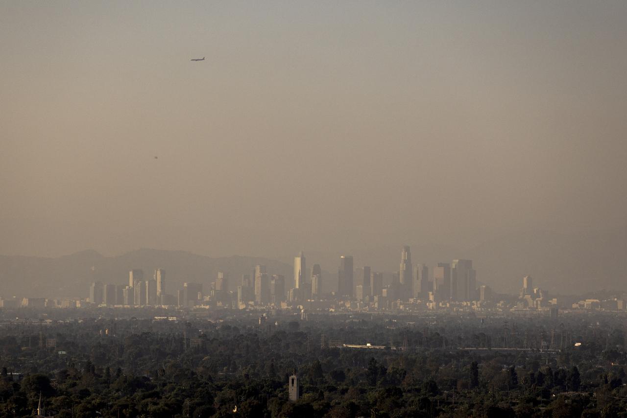 Une brume provenant de divers incendies de forêt plane sur le centre-ville de Los Angeles. [KEYSTONE - ETIENNE LAURENT]