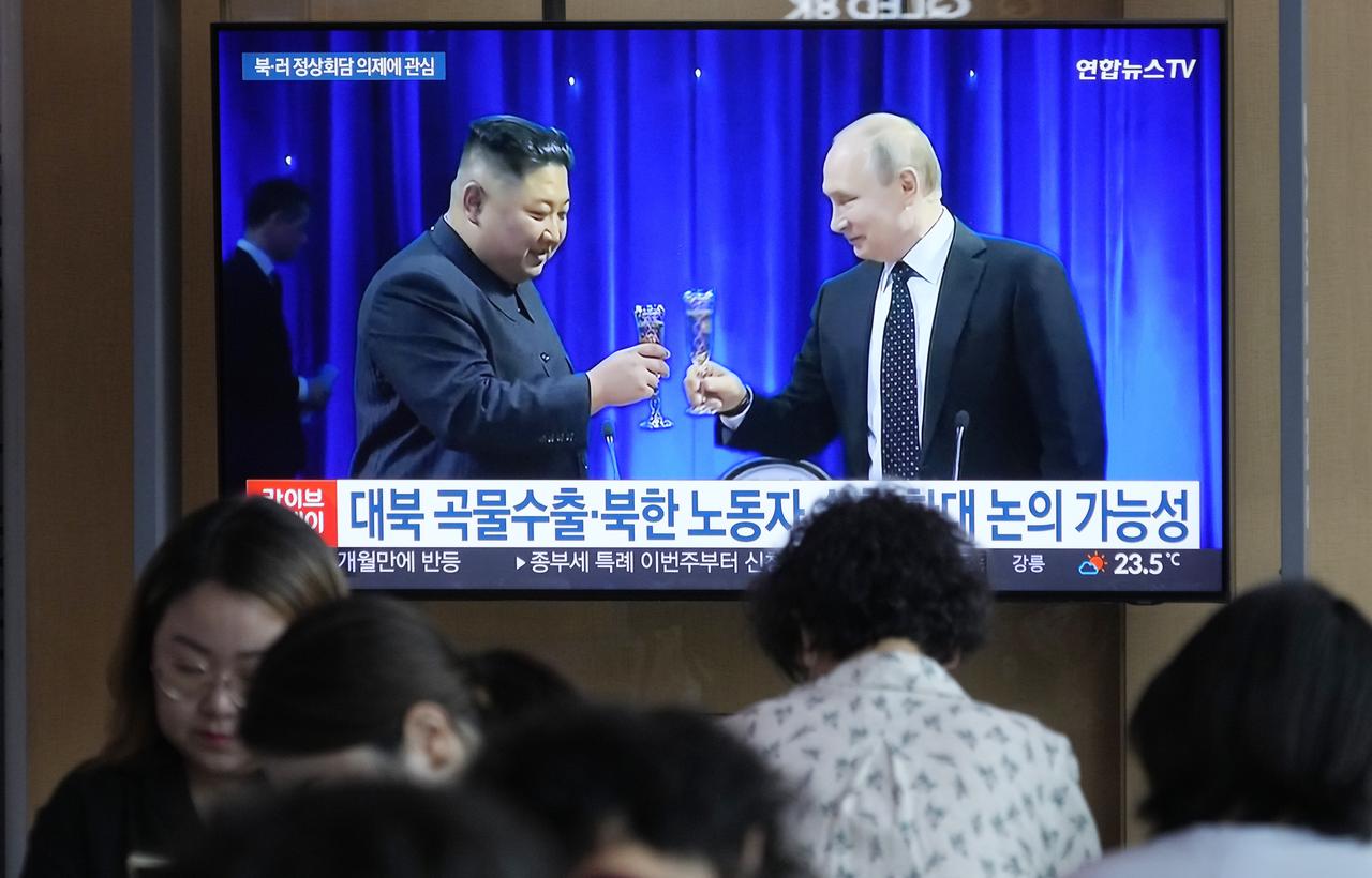 Un écran de télévision montre une image d'archive du dirigeant nord-coréen Kim Jong-un, à gauche, et du président russe Vladimir Poutine, à droite. [KEYSTONE - AHN YOUNG-JOON]