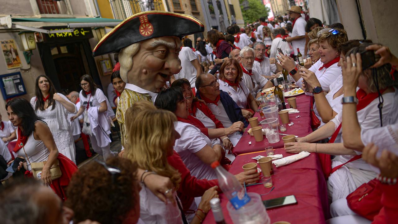 Un membre du "défilé des géants" pose avec des festivaliers lors des fêtes de San Fermín à Pampelune, en Espagne, le lundi 8 juillet 2024. [Keystone - AP Photo/Alvaro Barrientos]