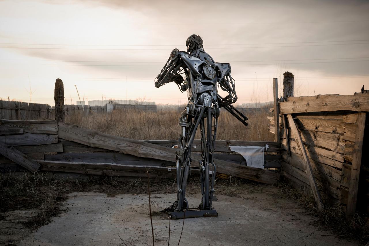 Une statue représentant le personnage du film Terminator, fabriquée à partir de pièces de transmission automobile, est placée près d'un poste de contrôle à Kiev, en Ukraine, le vendredi 25 mars 2022. [Keystone - Vadim Ghirda]