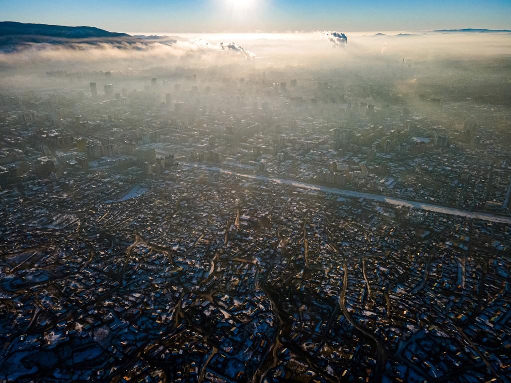 De nombreux nomades déracinés par le changement climatique s'établissent à Oulan-Bator, photographiée ici recouverte de son smog hivernal le 16 janvier 2022. [AFP - BYAMBASUREN BYAMBA-OCHIR]