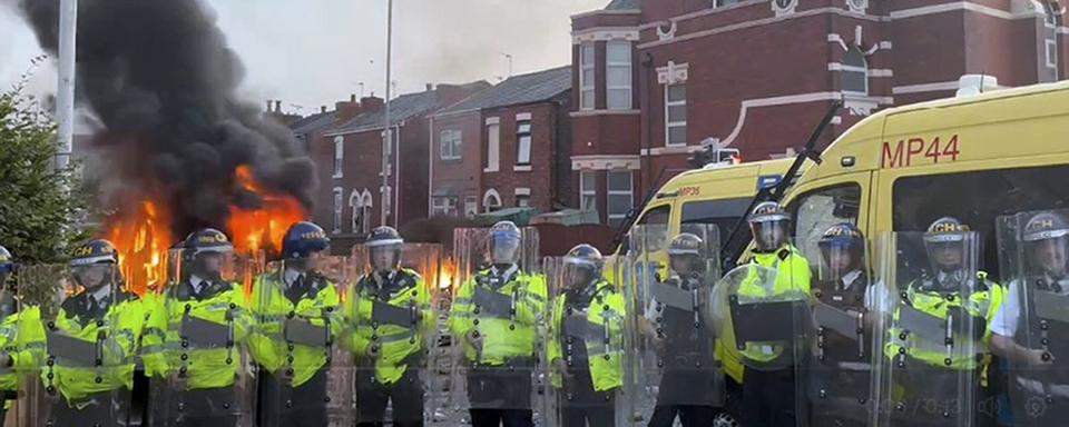 De violents affrontements ont opposé mardi soir policiers et manifestants à Southport. [Keystone - Pat Hurst/PA via AP]