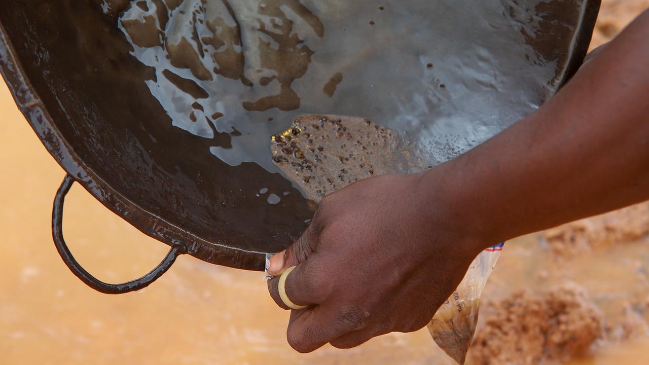 Un mineur cherche de l'or dans une mine illégale à Abomosu, au Ghana. [Keystone - Christian Thompson]