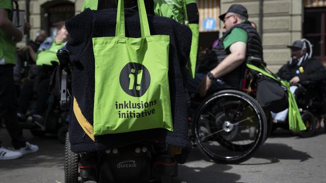 Un sac de l'Initiative pour l'inclusion est accroché à un fauteuil roulant lors du lancement de l'initiative populaire fédérale "Pour l'égalité des personnes handicapées", le jeudi 27 avril 2023 à Berne. [KEYSTONE - ANTHONY ANEX]