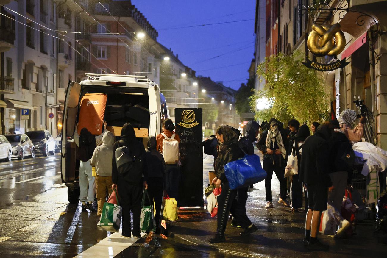 Des étudiants rangent leurs matelas dans un bus après l'évacuation du bâtiment d'Unitobler par la police, le 15 mai 2024 à Berne. [KEYSTONE - PETER KLAUNZER]