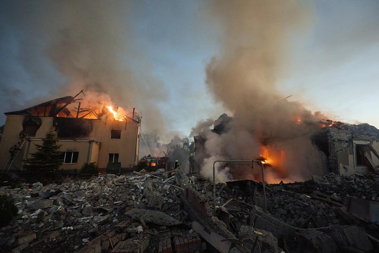 Des maisons en feu à Kharkiv, le 10 mai, après une frappe de missiles russes dans la nuit. [KEYSTONE - SERGEY KOZLOV]