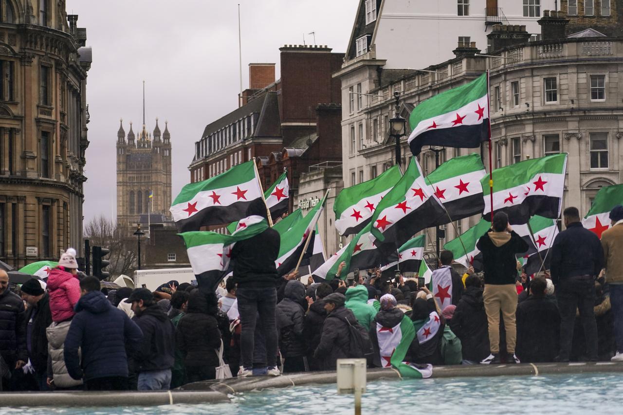 Des centaines de Syriens ont célébré dimanche sur Trafalgar Square au centre de Londres la chute de Bachar al-Assad. [KEYSTONE - ALBERTO PEZZALI]