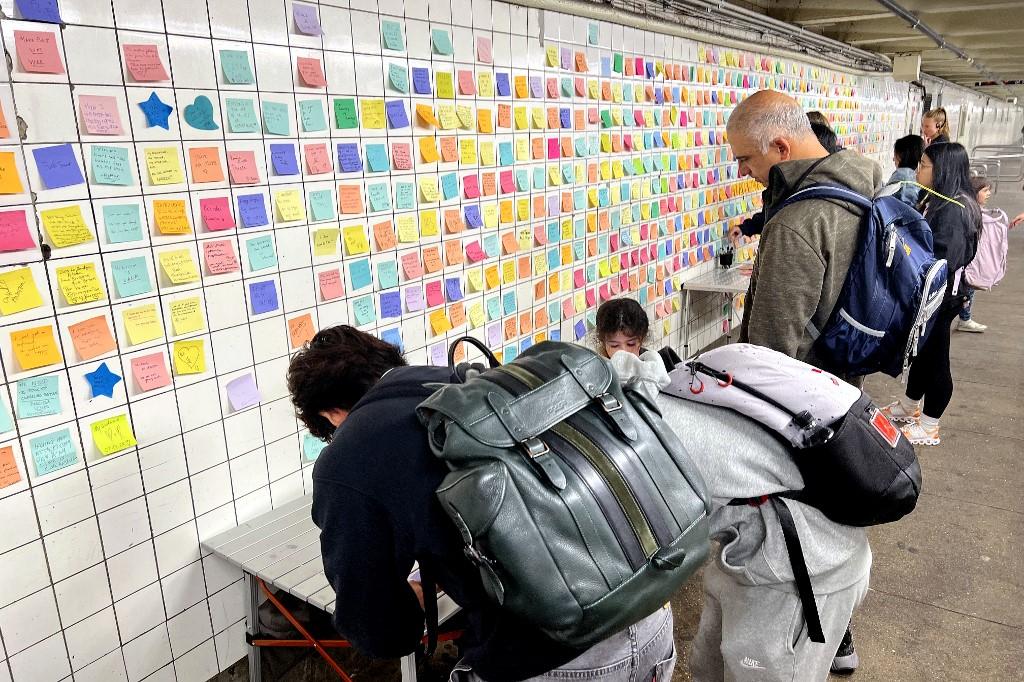 Sur le mur d'un couloir de métro à Manhattan, des New-Yorkais griffonnent petits mots, pensées et idées sur des Post-it. [AFP - Diane Desobeau]