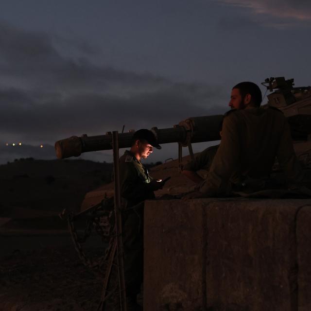 Des soldats israéliens sur un tank dans la région du Golan, à la frontière avec le Liban. [Keystone]