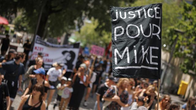 Des personnes manifestent contre les violences policières et en mémoire de Mike Ben Peter. [Keystone - Valentin Flauraud]