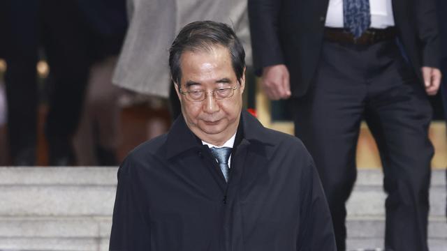 Le président sud-coréen par intérim Han Duck-soo sort du Parlement après sa destitution. [Yonhap via AP / Keystone - Hong Hae-in]