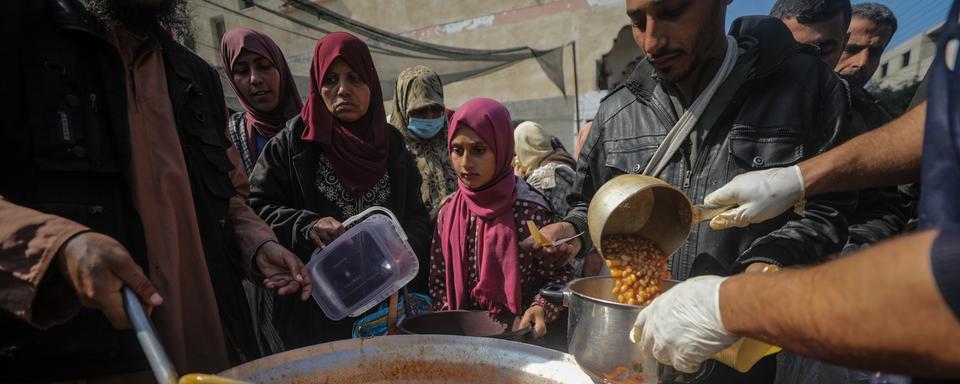 Les habitants de la bande de Gaza sont en proie à la famine à cause de la guerre entre le Hamas et Israël et l'UNWRA est la plus grosse organisation sur place à pouvoir lutter contre, grâce à son aide humanitaire. [Keystone - Mohammed Saber]