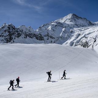 Des randonneurs s'exercent le long du parcours de la Patrouille des Glaciers. [Keystone - Jean-Christophe Bott]