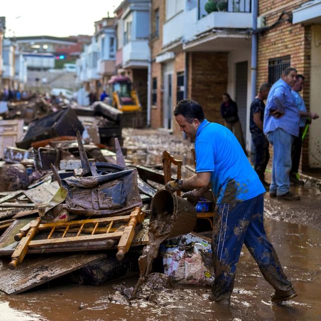 Une habitante de Utiel, petite ville près de Valence, nettoie sa maison après les inondations meurtrières qui ont touché la région. [Keystone - Manu Fernandez / AP]