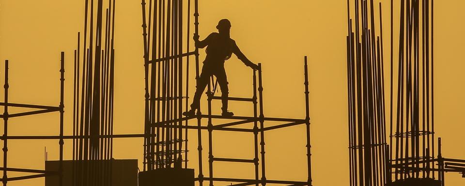 Un ouvrier indien en train de travailler sur un chantier du Gujarat lors d'une canicule en Asie du Sud-Est. [Keystone/EPA - Divyakant Solanki]