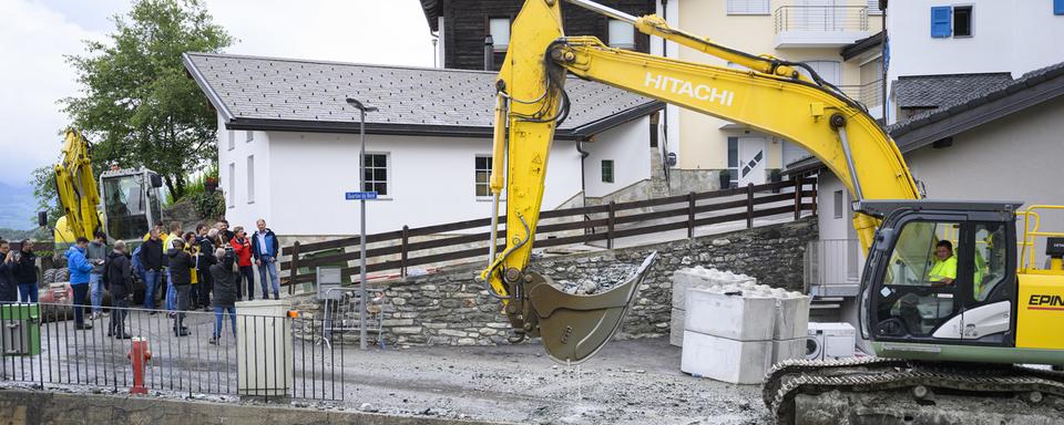 Début des travaux de remise en état à Chippis après les intempéries en Valais. [Keystone - Jean-Christophe Bott]