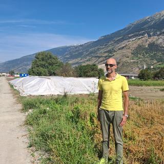 Yves Degoumois, chef de section - Sites pollués, sols et eaux souterraines du canton du Valais, devant un tas de sol pollué au mercure, sur le chantier d'assainissement le long du canal entre Viège et Rarogne en Valais. [RTS - Sarah Dirren]