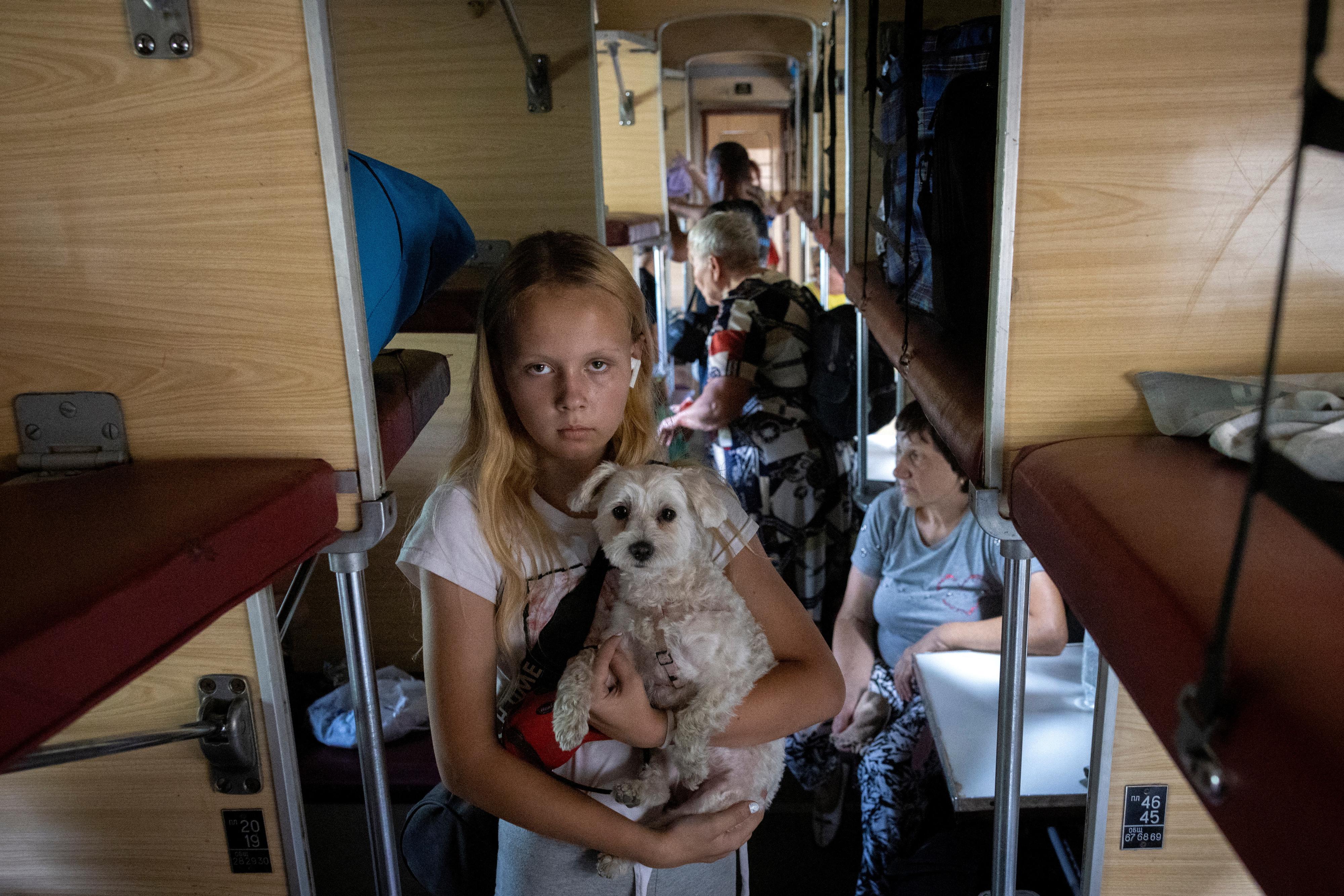 Une jeune tient son chien dans ses bras à bord d'un train d'évacuation pour fuir avec sa famille l'avancée des troupes russes à Pokrovsk, le 22 août 2024 (image d'illustration). [REUTERS - Thomas Peter]