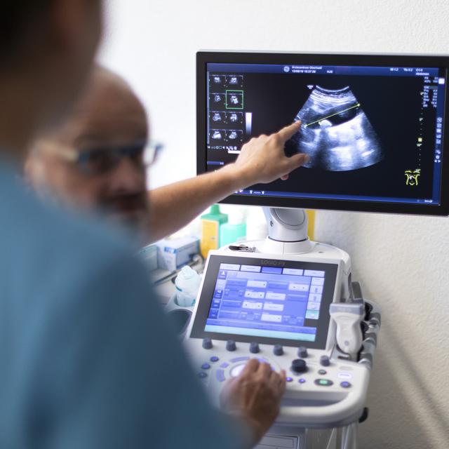 Un médecin explique une image échographique à un assistant médical, au centre médical Oberhasli à Meiringen, le 13 août 2019 (image d'illustration). [keystone - Gaétan Bally]