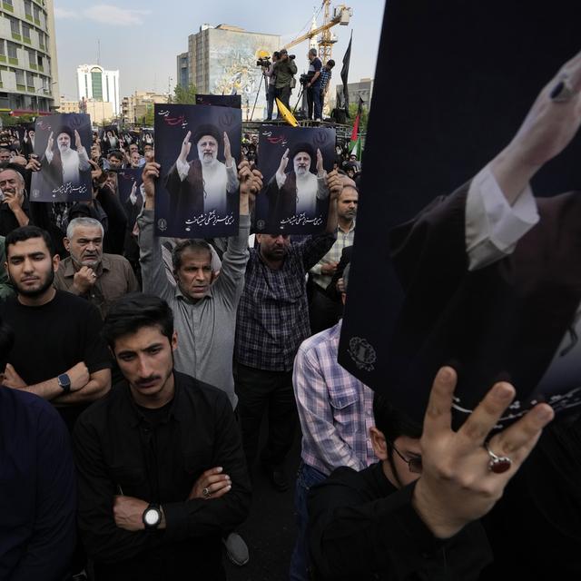 Des hommes avec des images d'Ebrahim Raïssi en Iran. [Keystone/AP Photo - Vahid Salemi]