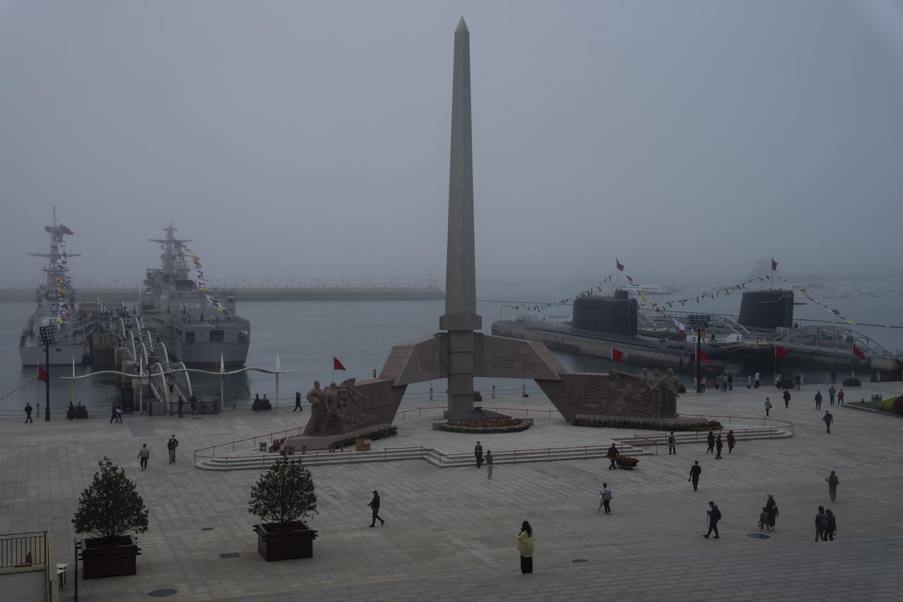 Des visiteurs observent des navires de guerre et des sous-marins à la retraite au musée naval de l'Armée populaire de libération de Chine à Qingdao, dans la province de Shandong, dans l'est de la Chine, le mardi 23 avril 2024. [KEYSTONE - NG HAN GUAN]