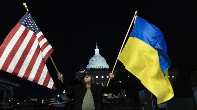 Des partisans du soutien à l'Ukraine brandissent des drapeaux devant le Capitole américain à Washington le 23 avril 2024 après l'adoption par le Sénat d'une aide supplémentaire. [KEYSTONE - MICHAEL REYNOLDS]