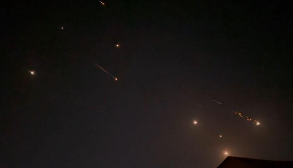 Une capture d'une vidéo prise par AFPTV montre des explosions illuminant le ciel à Hébron, en Cisjordanie occupée, lors d'une attaque iranienne contre Israël. [AFP - -]