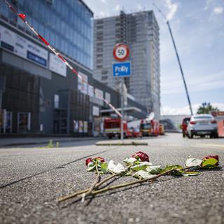 Des fleurs en hommage aux personnes décédées après l'effondrement de l'échafaudage le samedi 13 juillet 2024 a Prilly. [Keystone - Valentin Flauraud]