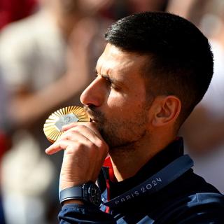 Le Serbe Novak Djokovic est le champion olympique de tennis après avoir battu l'Espagnol Carlos Alcaraz. [Keystone/EPA - Caroline Blumberg]