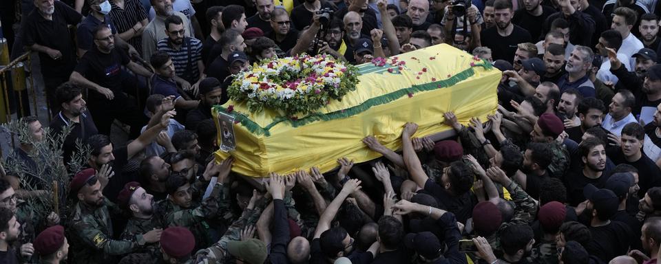 Des combattants du Hezbollah qui honorent le corps de leurs camarades tués par des bipeurs piégés par Israël. [Keystone/AP Photo - Bilal Hussein]